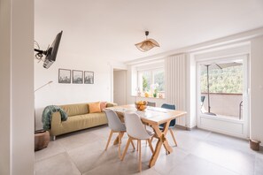 Un comedor con mesa, sillas, un sofá y una ventana con vistas.