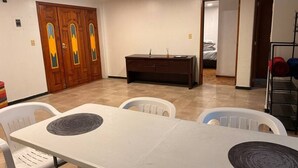 A dining area with a white table and chairs, a wooden cabinet, and a door with decorative glass panels. - Dpto.sensillo, Foro Sol, GNP y Aeropuerto (Mexico City)
