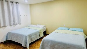 Two single beds with headboards, a wooden floor, a white curtain, and a light-colored wall. - Dpto.sensillo, Foro Sol, GNP y Aeropuerto (Mexico City)