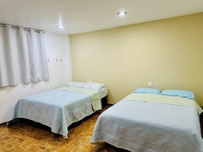 Two single beds with headboards, a wooden floor, a white curtain, and a light-colored wall. - Dpto.sensillo, Foro Sol, GNP y Aeropuerto (Mexico City)