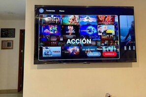 Un televisore mostra l'interfaccia di un servizio di streaming con diverse opzioni di film.