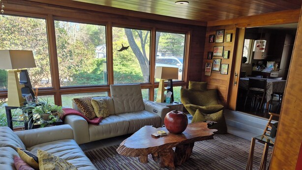 A cozy living room with a sofa, armchair, and a wooden coffee table.