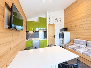 A compact kitchen with a dining area and a sofa. - 10m from ski slopes, 4th floor, view valley, balcony, tv, ski locker, 24m², Les Menuires (Les Menuires)
