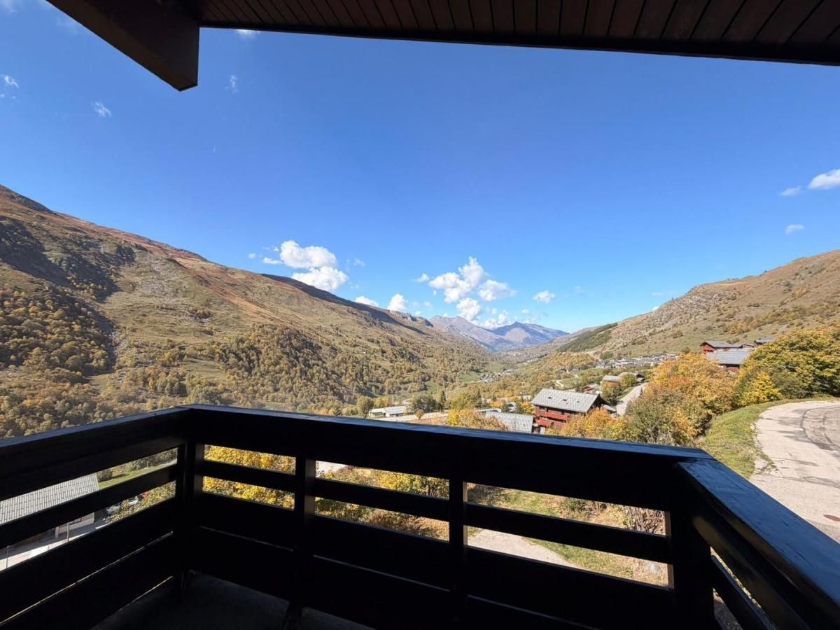 Un balcón con vistas a un valle y montañas.