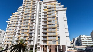 A multi-story hotel with balconies, a swimming pool, and a palm tree. - Sagan Brown Apartment, Armação de Pêra, Algarve (Armação de Pêra)