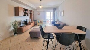 A modern living room with a dining area, a TV, and a sofa. - Casa Athenia Inn (Athina)
