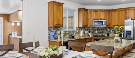 Una cocina moderna con armarios de madera, encimeras de granito y una isla central.