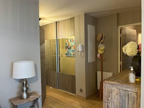 Ein modernes Badezimmer mit einem Holzbadezimmermöbel, einem Spiegel, einem Handtuchhalter und einem an der Wand befestigten Telefon.