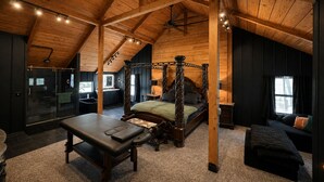 Une chambre à coucher avec un lit à baldaquin, un bureau, un banc et un canapé.