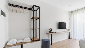 A modern room with a built-in seating area, a flat-screen TV, and a wooden floor.