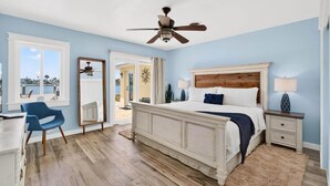 Una camera da letto con un grande letto, una ventola a soffitto, una scrivania e una sedia.