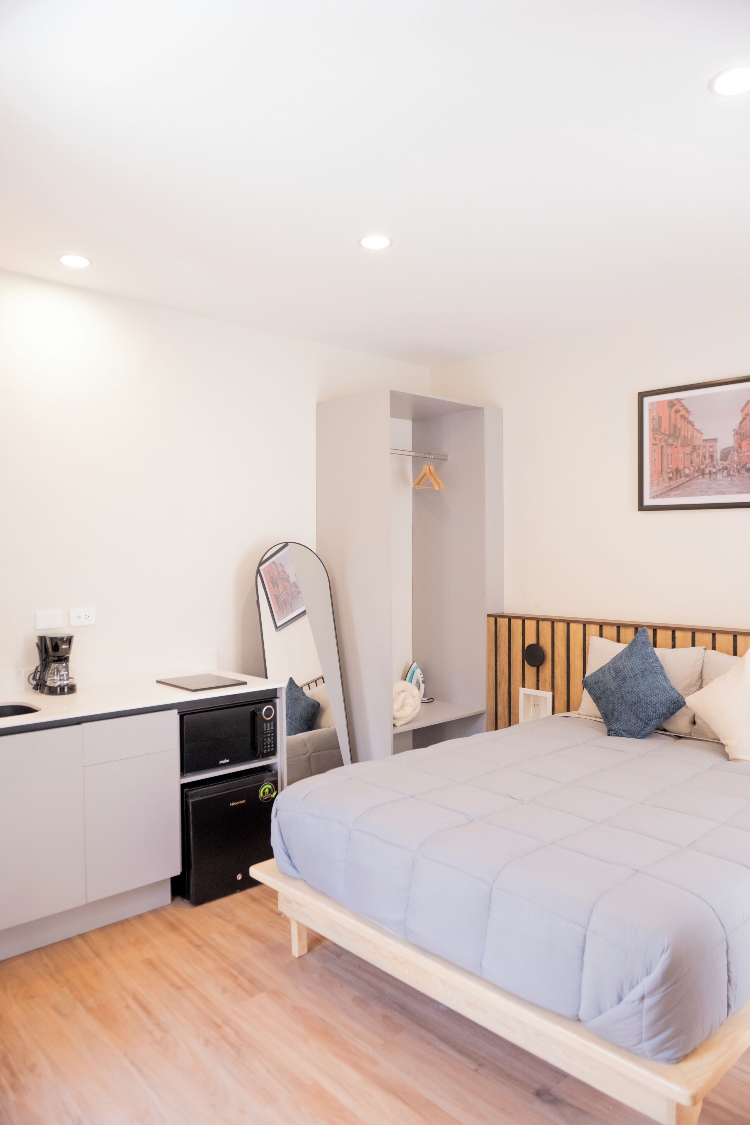 Un dormitorio con cama, mesita de noche y escritorio con silla.