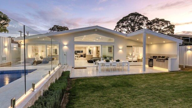 Una casa moderna con piscina, comedor y cocina.