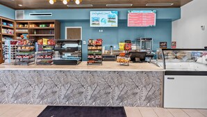 A snack bar with shelves stocked with chips and snacks, a refrigerated display case, and a menu board advertising a 'Breeze Canteen' and 'Volleyball Court'. - 5BR townhouse at Windsor Cay Resort (Clermont)