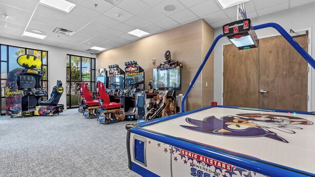 An indoor arcade with various gaming machines, including a pool table with a Sonic the Hedgehog design. - 5BR townhouse at Windsor Cay Resort (Clermont)