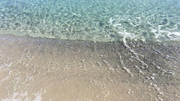A beach with clear water, pebbly shore, and a visible sandbar. - New Orange Studio Apartment in Limpiddu, Budoni – Pool, Terrace, Wi-Fi (Budoni)