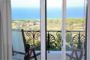 Ein Balkon mit Blick auf das Meer und eine Stadt.