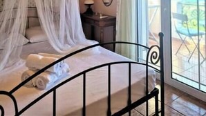 Una camera da letto con un letto a baldacchino, un comodino, un condizionatore d'aria e vista sull'esterno.