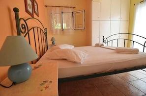 A bedroom with a bed, a nightstand with a lamp, a window with curtains, and a wardrobe. - Alta Mare Villa-Apart-Sea View- Nature- Relax ♥ (Zakynthos)