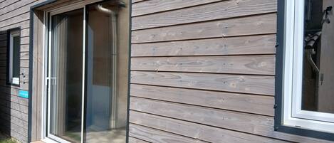 A wooden exterior wall with large windows and a visible door.