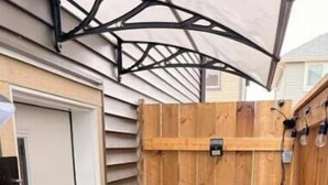 A wooden outdoor shower area with a concrete floor and a metal roof structure. - Private Suite w/ Full Kitchen Near Banff National Park (Cochrane)