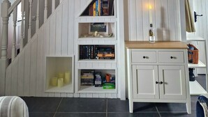 Eine Treppe mit weißen Geländern und einer weißen Wand, die Einbauschränke mit Büchern und dekorativen Gegenständen enthält.