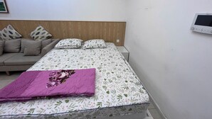 Un dormitorio con cama, sofá y aire acondicionado instalado en la pared.