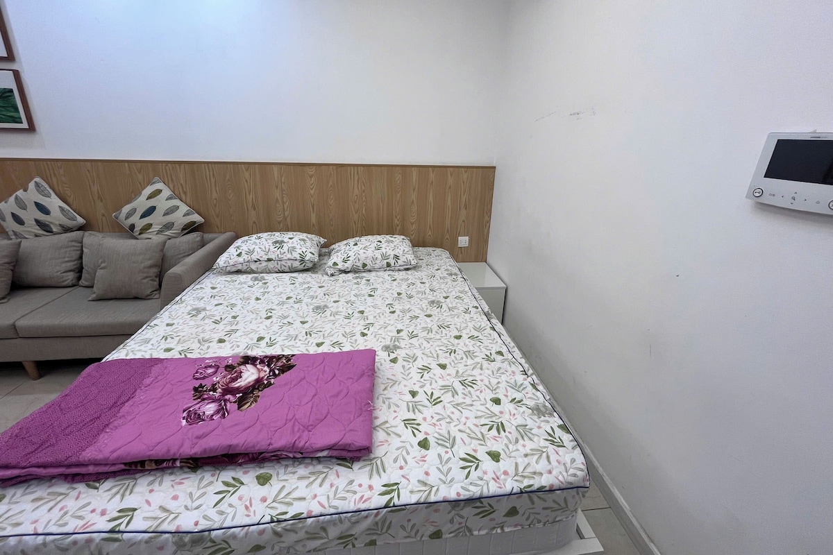 Un dormitorio con cama, sofá y aire acondicionado instalado en la pared.