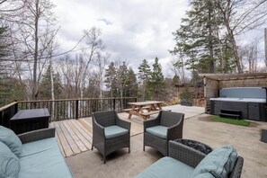 Eine Terrassenausstattung mit Korbmöbeln, einem Picknicktisch und einem Grill.