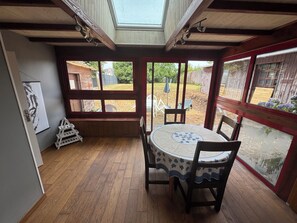 A room with a wooden floor, a round table with chairs, large windows, and a skylight. - Just minutes from everything! Family townhouse close to all amenities (Bannalec)