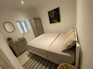 Tabla de planchar con plancha y ropa de cama 