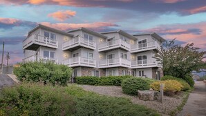A multi-story building with balconies, surrounded by greenery. - Marina-Front Retreat - Steps to Beach, Wine & Water (Algoma)