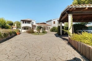 A residential property with a paved driveway leading to a covered patio area. - Apartment 'Annina' with Private Terrace, Wi-Fi and Air Conditioning (Pittulongu)