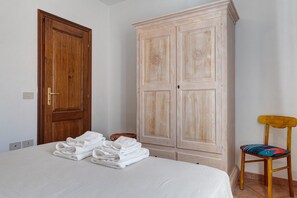 Ein Schlafzimmer mit einem Bett, einem Holzschrank und einem Stuhl.