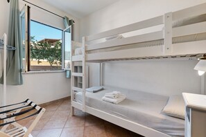 A bunk bed room with a window, a towel rack, and a small table. - Apartment 'Annina' with Private Terrace, Wi-Fi and Air Conditioning (Pittulongu)