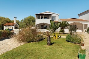 A two-story house with a garden, a stone pathway, and a small building with a red roof. - Apartment 'Annina' with Private Terrace, Wi-Fi and Air Conditioning (Pittulongu)
