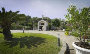 A courtyard with a small building, a palm tree, and potted plants. - Apartment 'Zio Tonino' with Private Terrace, Wi-Fi and Air Conditioning (Pittulongu)