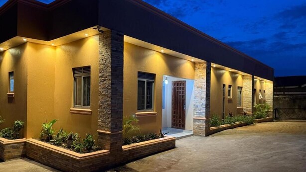 A modern building with a flat roof, a front entrance with a door, and a covered patio area.