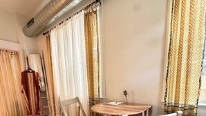 A room with a round wooden table, two white chairs, a white rug, and patterned curtains. - Light-Filled Boho Studio Alcove Retreat in Philly’s Best Neighborhood , new Deck (Philadelphia)