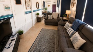 Una sala de estar con sofá, mesa de centro, chimenea y alfombra.