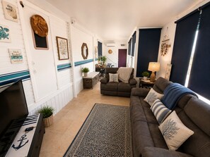 Ein Wohnzimmer mit Sofa, Couchtisch, Kamin und Teppich.