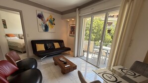Un salon moderne comprenant un canapé, des fauteuils, une table basse et une table à manger.