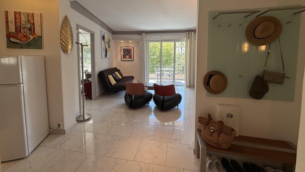 Un vaste espace de vie comprenant une cuisine moderne, un coin repas et un balcon avec vue.