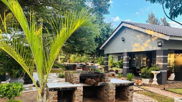 A house with a stone patio, potted plants, and a small outdoor seating area. - Studio in Golden Acres – Kwekwe - 2371 (Kwekwe)
