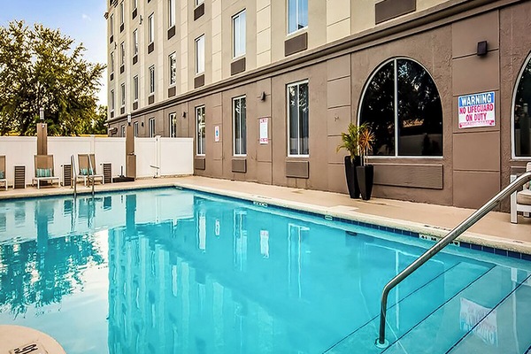 Dive into a refreshing swim in the sunlit outdoor pool.