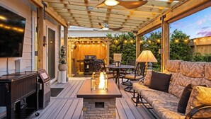 A covered outdoor patio with a fire pit, seating, and a grill area. - Private 30A Beach Retreat - Coastal Backyard Oasis (Santa Rosa Beach)