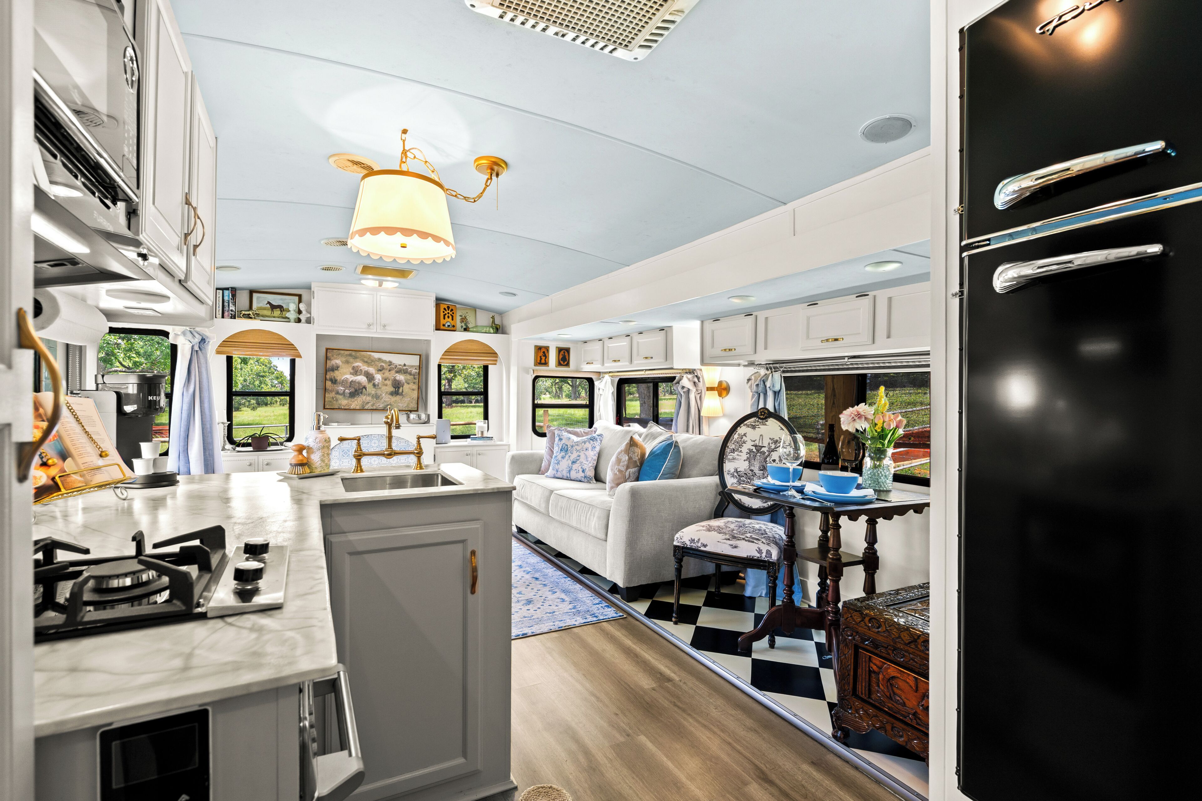 A compact RV interior with a kitchen area, dining space, and a living area.