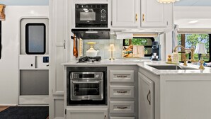 Una cucina moderna con elettrodomestici integrati, un'isola centrale e vista sull'esterno.