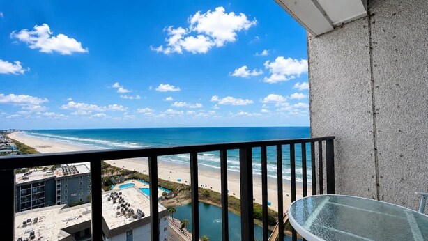 A balcony with a view of the beach and ocean. - Bright Beachfront Studio + Pool (Myrtle Beach)