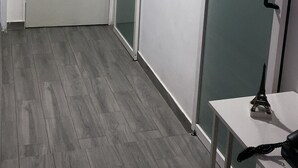 Käytävä, jossa on liukuovi, ovi, jossa on kahva, ja pieni pöytä, jonka päällä on lamppu.